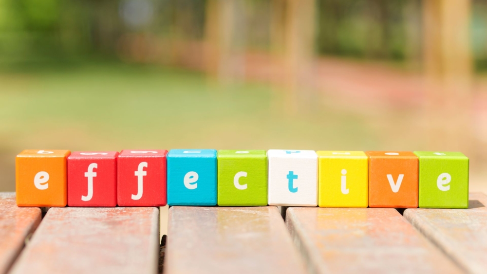 A beautiful colourful picture with wooden cubes in different colours that have a letter on each side. The cubes next to each other spell the word 'effective'